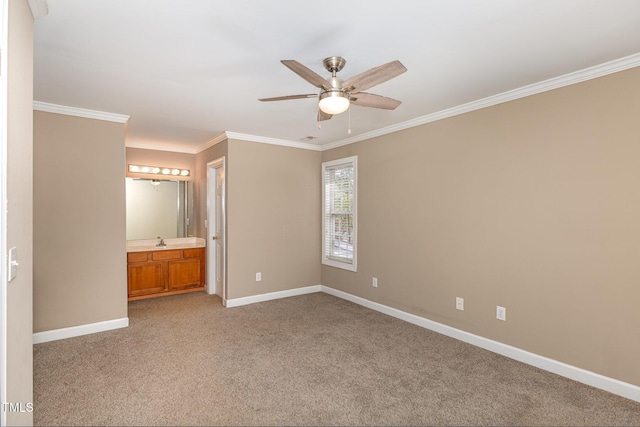 unfurnished bedroom with crown molding, light carpet, connected bathroom, a sink, and baseboards