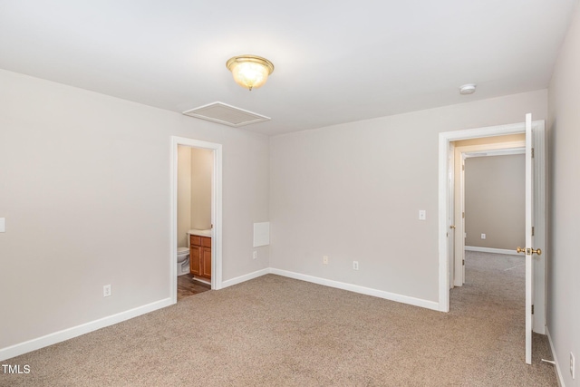 interior space featuring connected bathroom, carpet flooring, visible vents, baseboards, and attic access