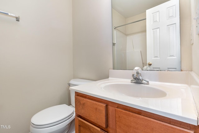 bathroom with a shower, vanity, and toilet