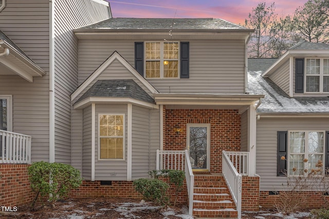 view of front facade with a shingled roof and crawl space