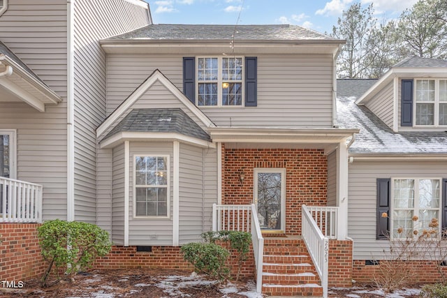 view of front of house with a shingled roof and crawl space