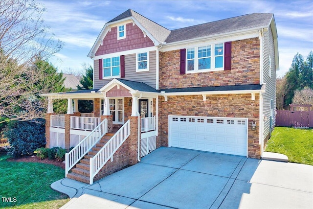 view of front facade featuring stone siding, a porch, concrete driveway, a front yard, and an attached garage