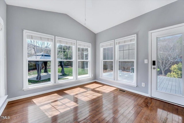 unfurnished sunroom featuring visible vents, a healthy amount of sunlight, and vaulted ceiling