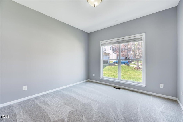 spare room featuring carpet, baseboards, and visible vents