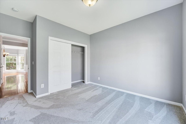 unfurnished bedroom featuring a closet, baseboards, and carpet