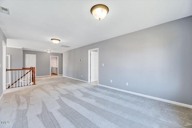 empty room with visible vents, baseboards, and light carpet