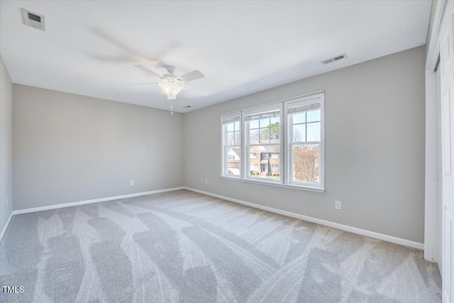 carpeted empty room featuring visible vents, baseboards, and a ceiling fan