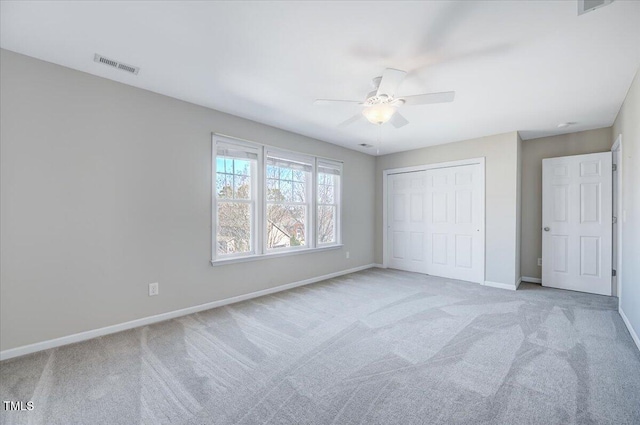 unfurnished bedroom with visible vents, baseboards, carpet flooring, a closet, and a ceiling fan