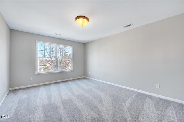 empty room featuring visible vents, baseboards, and carpet flooring