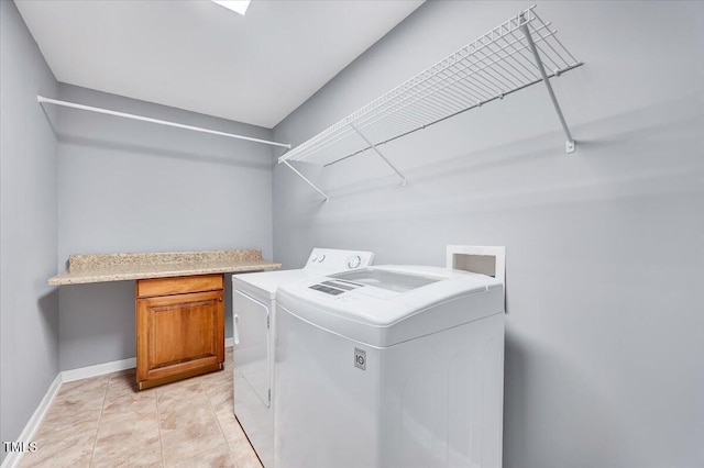 clothes washing area featuring light tile patterned floors, laundry area, washer and dryer, and baseboards