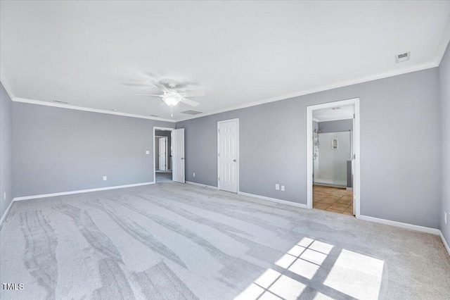 unfurnished bedroom featuring carpet flooring, a ceiling fan, baseboards, and ornamental molding