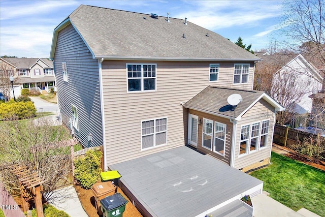 rear view of property with fence, roof with shingles, and a wooden deck