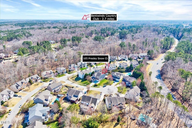 drone / aerial view featuring a residential view and a view of trees