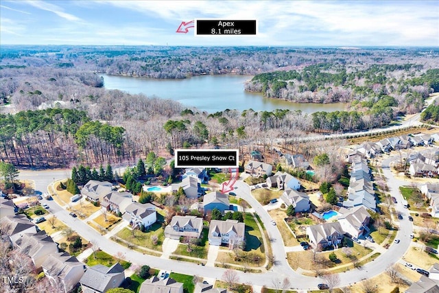 drone / aerial view with a residential view, a view of trees, and a water view