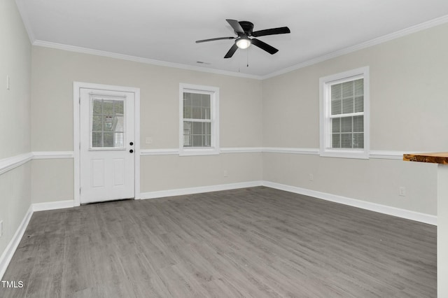 unfurnished room featuring a ceiling fan, crown molding, baseboards, and wood finished floors