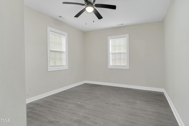 spare room featuring visible vents, baseboards, and wood finished floors