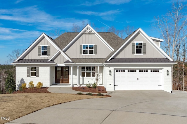 view of front of house with french doors, brick siding, a standing seam roof, a garage, and driveway