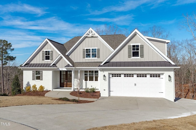 view of front of home featuring brick siding, an attached garage, board and batten siding, a standing seam roof, and driveway