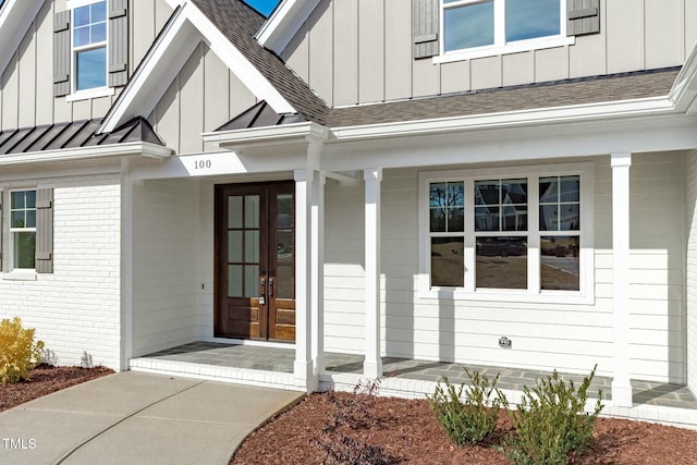 view of exterior entry with a standing seam roof, board and batten siding, and french doors