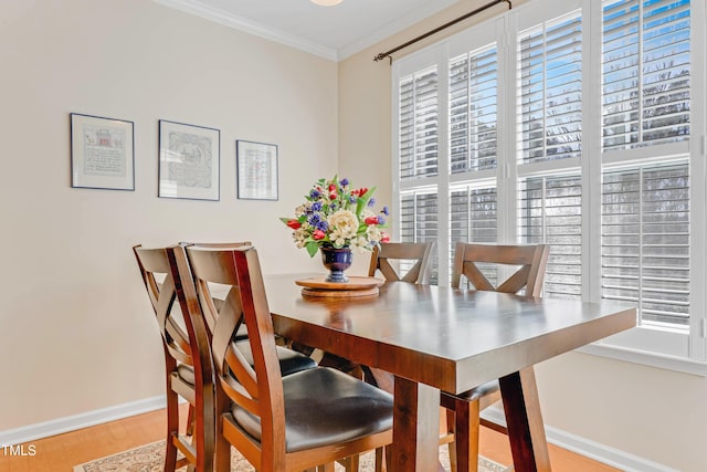 dining area with baseboards, crown molding, and wood finished floors