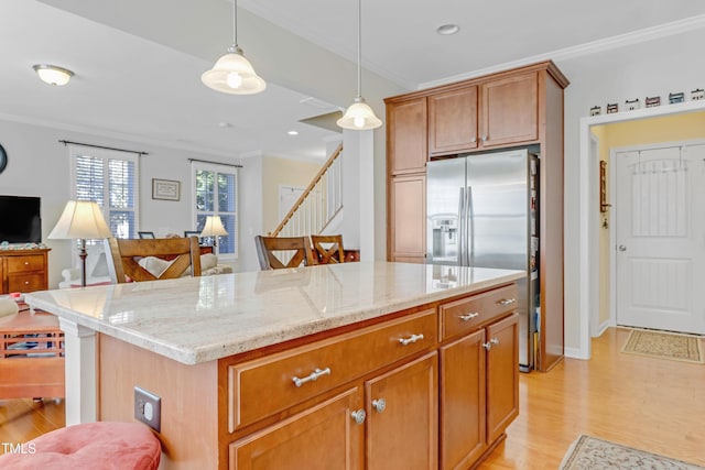 kitchen with ornamental molding, light wood-type flooring, stainless steel fridge, and light stone countertops