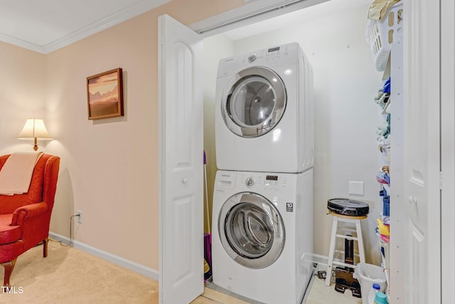 clothes washing area with stacked washer and dryer, ornamental molding, light carpet, laundry area, and baseboards