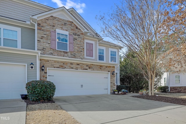 townhome / multi-family property featuring a garage, driveway, and stone siding