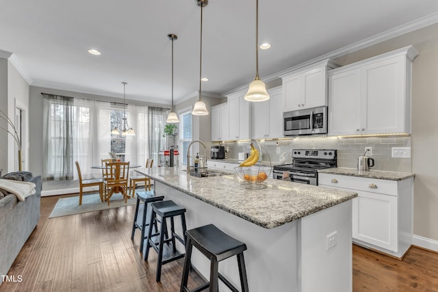 kitchen with crown molding, appliances with stainless steel finishes, dark wood finished floors, and a sink