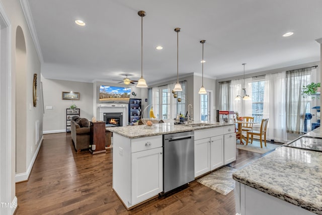 kitchen with dark wood-type flooring, a sink, a lit fireplace, dishwasher, and crown molding