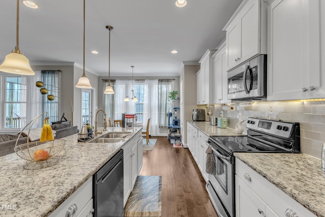 kitchen with a sink, appliances with stainless steel finishes, decorative backsplash, dark wood-style floors, and crown molding