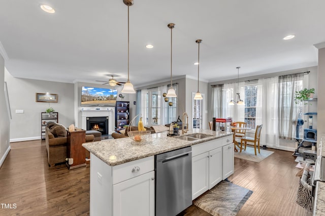 kitchen with dark wood-type flooring, ornamental molding, a sink, a warm lit fireplace, and dishwasher