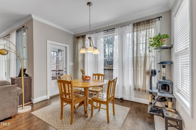 dining room featuring ornamental molding, wood finished floors, and baseboards