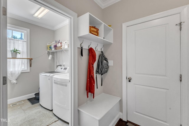 washroom featuring washing machine and clothes dryer, visible vents, ornamental molding, laundry area, and baseboards