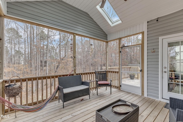 sunroom featuring vaulted ceiling with skylight