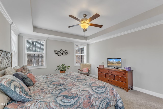 bedroom with baseboards, a ceiling fan, a tray ceiling, crown molding, and carpet flooring