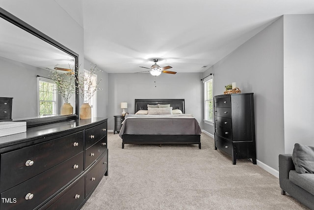 bedroom featuring light carpet, ceiling fan, and baseboards