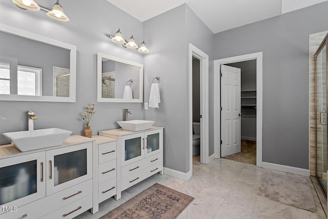 bathroom with double vanity, a stall shower, and a sink