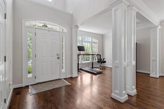 foyer entrance with decorative columns, visible vents, ornamental molding, and dark wood-type flooring