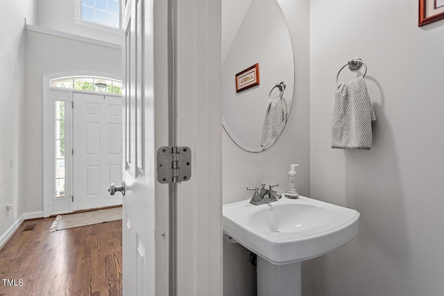 bathroom with a sink, wood finished floors, and baseboards