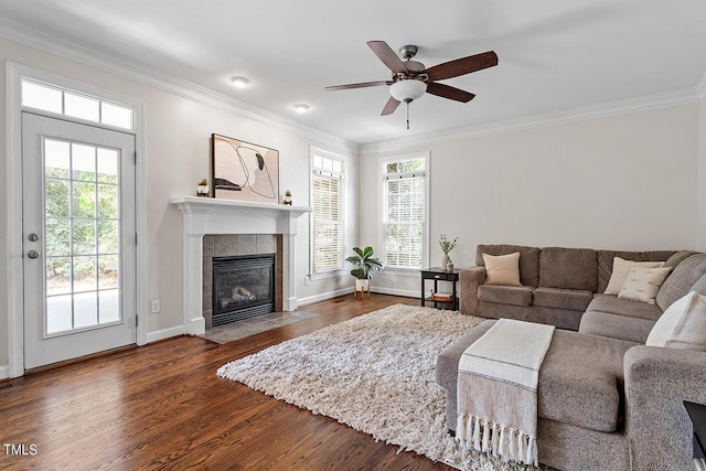 living room featuring a healthy amount of sunlight, ornamental molding, and dark wood finished floors