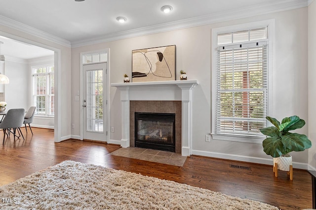 living room with a fireplace, crown molding, and wood finished floors