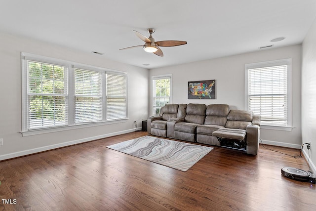 living room with ceiling fan, wood finished floors, visible vents, and baseboards