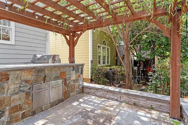 view of patio / terrace with exterior kitchen, fence, a pergola, and area for grilling