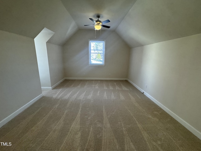 additional living space with vaulted ceiling, carpet, a ceiling fan, and baseboards