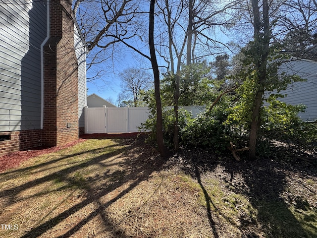 view of yard featuring fence and a gate