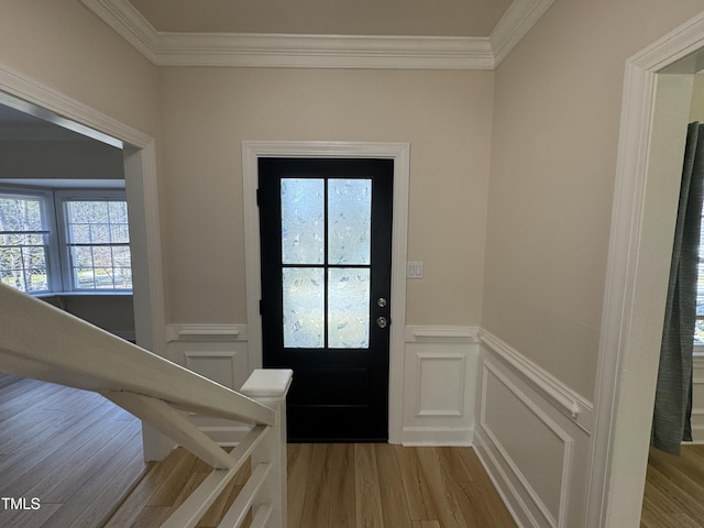 entryway with a wainscoted wall, ornamental molding, and wood finished floors