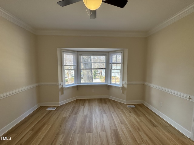 spare room with light wood-style floors, visible vents, and baseboards