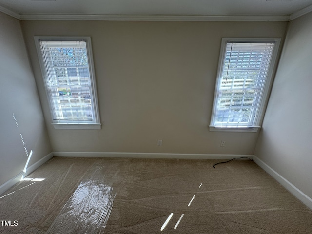 carpeted empty room with baseboards and crown molding