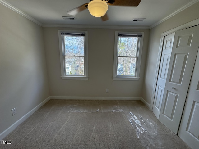 unfurnished bedroom featuring multiple windows, crown molding, and visible vents