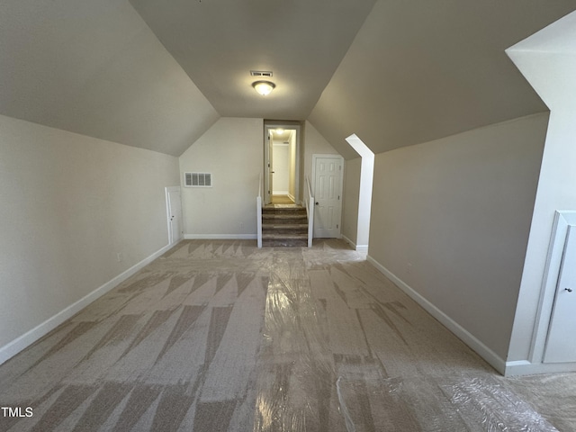 bonus room with carpet floors, baseboards, visible vents, and vaulted ceiling